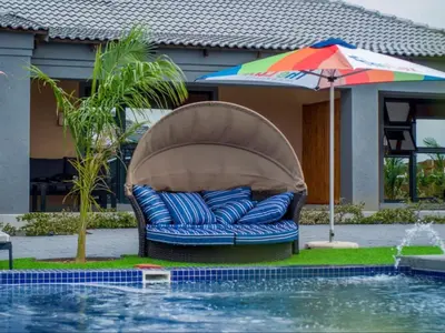 a chair and an umbrella next to a pool at The Lux Hotel and Resorts in Louis Trichardt