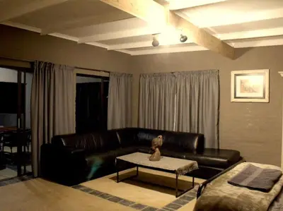 a living room with a leather couch and a table at Horizon Savannah in Dinokeng Game Reserve
