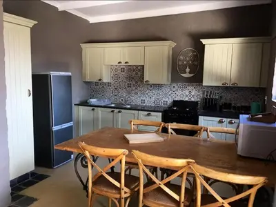 a kitchen with a wooden table with chairs and a refrigerator at Horizon Savannah in Dinokeng Game Reserve