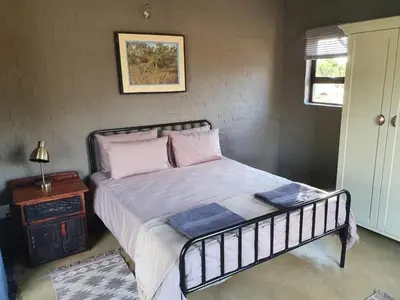a bedroom with a bed and a table and a window at Horizon Savannah in Dinokeng Game Reserve