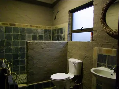 a bathroom with a toilet and a sink and a window at Horizon Savannah in Dinokeng Game Reserve