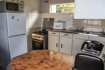 a kitchen with a white refrigerator and a stove at Panorama Chalets & Rest Camp in Graskop