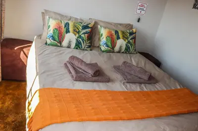 a bed with two pillows and two mitts on it at Panorama Chalets & Rest Camp in Graskop