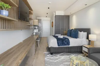 a bedroom with a bed and a living room at Ellipse Waterfall 31002 in Midrand
