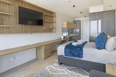 a bedroom with a large bed with a flat screen tv at Ellipse Waterfall 31002 in Midrand
