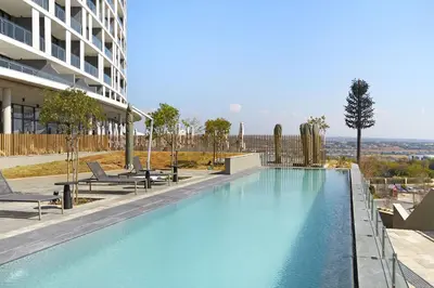 a large swimming pool on the side of a building at Ellipse Waterfall 31002 in Midrand