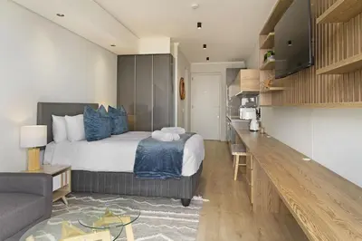 a bedroom with a bed and a living room at Ellipse Waterfall 31015 in Midrand