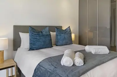 a bedroom with a large bed with blue pillows and towels at Ellipse Waterfall 31015 in Midrand