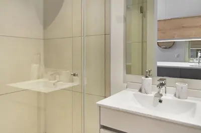 a white bathroom with a sink and a shower at Ellipse Waterfall 31015 in Midrand