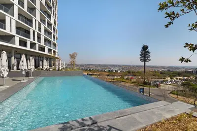 a swimming pool in front of a building at Ellipse Waterfall 31015 in Midrand