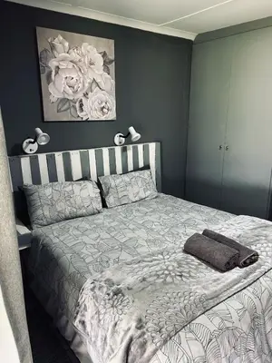 a bedroom with a bed with a gray wall at The Wool House & Pablo's carolina in Carolina