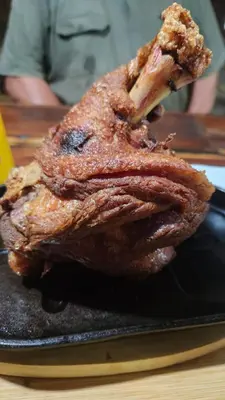a piece of meat sitting on a black plate at The Wool House & Pablo's carolina in Carolina