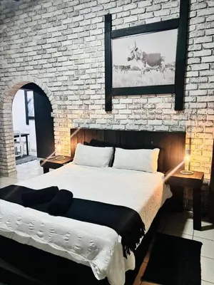 a bedroom with a large bed and a brick wall at The Wool House & Pablo's carolina in Carolina
