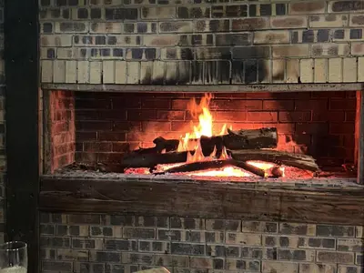 a brick fireplace with a fire in it at The Wool House & Pablo's carolina in Carolina
