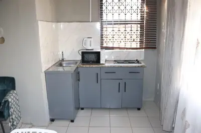 a small kitchen with a sink and a microwave at Unitrainview guest house in Pretoria