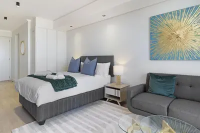 a bedroom with a bed and a couch at Ellipse Waterfall 3902 in Midrand