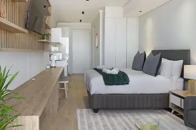 a bedroom with a large bed and a kitchen at Ellipse Waterfall 3902 in Midrand
