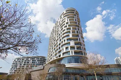 a tall white building with a sky in the background at Ellipse Waterfall 3902 in Midrand