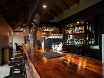 a bar with a wooden counter and some bar stools at Shekinah Lion & Game Lodge in Dryfsand