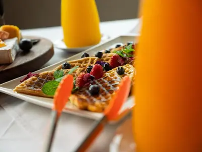 a table with two plates of waffles with fruit on them at Shekinah Lion & Game Lodge in Dryfsand