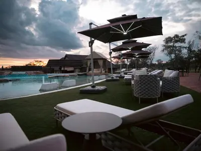 a group of tables and chairs next to a pool at Shekinah Lion & Game Lodge in Dryfsand