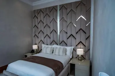 a bedroom with a bed and two tables with lamps at Mekete Boutique & Events in Polokwane