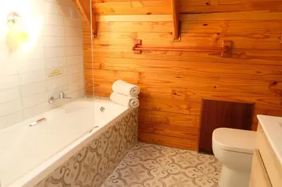 a bathroom with a bath tub and a toilet at Mountain View Cottage in Dullstroom
