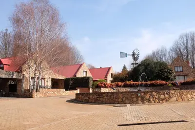a building with a stone wall and a street at Mountain View Cottage in Dullstroom