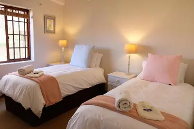 a bedroom with two beds with towels on them at Mountain View Cottage in Dullstroom