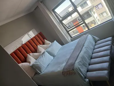 a bedroom with a bed with pillows and a window at Spacious 2 Bedroom Apartment in Carslwald, Midrand - Business and Family friendly - 2 Elizabeth Place in Midrand