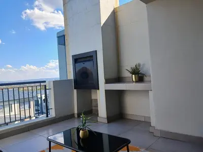 a living room with a tv on a balcony at Spacious 2 Bedroom Apartment in Carslwald, Midrand - Business and Family friendly - 2 Elizabeth Place in Midrand