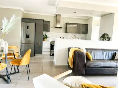 a living room with a couch and a kitchen at Spacious 2 Bedroom Apartment in Carslwald, Midrand - Business and Family friendly - 2 Elizabeth Place in Midrand