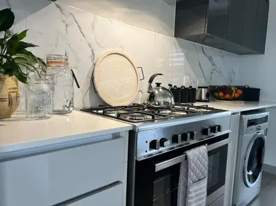 a kitchen with a stove and a washing machine at Spacious 2 Bedroom Apartment in Carslwald, Midrand - Business and Family friendly - 2 Elizabeth Place in Midrand