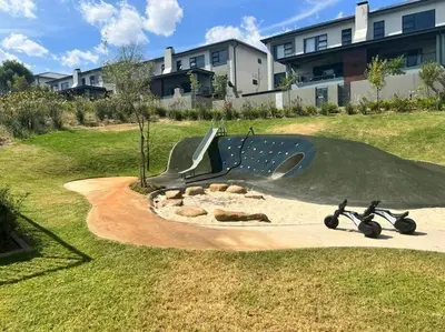 a playground with a slide and a scooter in a yard at Spacious 2 Bedroom Apartment in Carslwald, Midrand - Business and Family friendly - 2 Elizabeth Place in Midrand