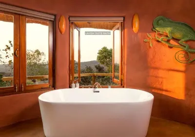 a white bath tub in a room with windows at Leshiba Wilderness in Louis Trichardt