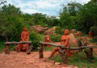 three statues of men sitting on a bench at Leshiba Wilderness in Louis Trichardt
