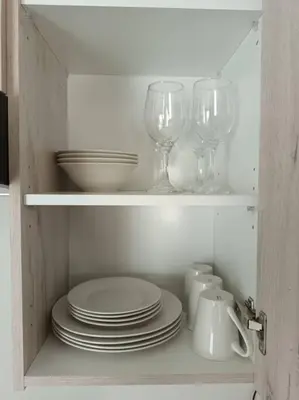 a cupboard with plates and wine glasses in it at The Blissful Abode by BK Hospitable in Midrand