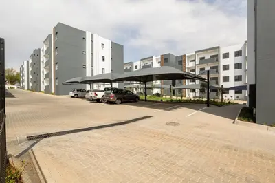 a parking lot with umbrellas in front of buildings at The Blissful Abode by BK Hospitable in Midrand