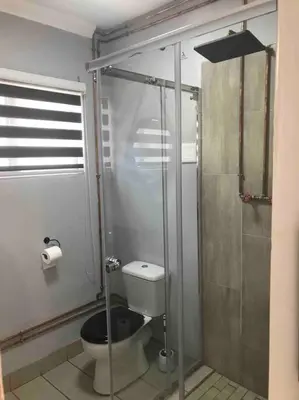 a bathroom with a toilet and a shower at Red Lotus Studio Pta East-No Loadshedding in Pretoria