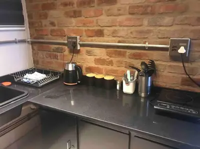 a kitchen counter with a stove and a brick wall at Red Lotus Studio Pta East-No Loadshedding in Pretoria