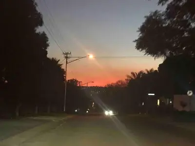 a street with a street light with a sunset in the background at Red Lotus Studio Pta East-No Loadshedding in Pretoria
