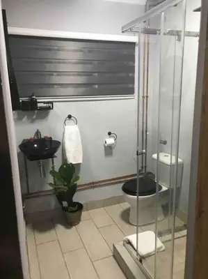 a bathroom with a shower and a toilet and a sink at Red Lotus Studio Pta East-No Loadshedding in Pretoria