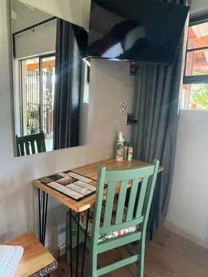 a table and a chair in a kitchen with a mirror at Khululeka Safaris Lodge in White River