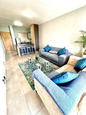 a living room with a couch and a table at The Place @ Mall of Africa in Midrand