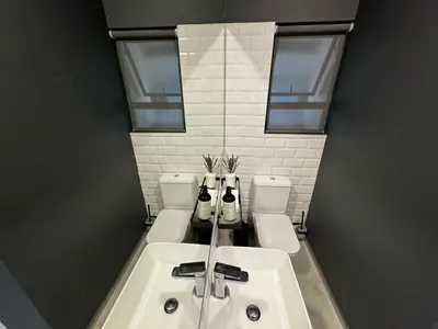 a bathroom with a sink and two toilets at Rand Corner Crib in Pretoria