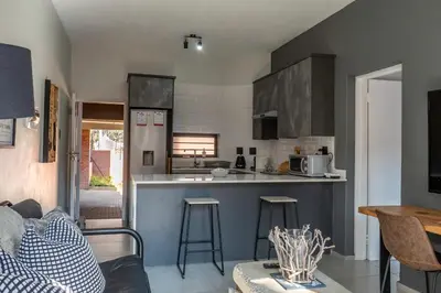 a kitchen and living room with a couch and a table at Rand Corner Crib in Pretoria