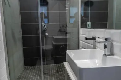 a bathroom with a shower and a sink at Rand Corner Crib in Pretoria