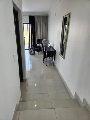 a hallway with a piano and a living room at La Chambre Manor House in Nelspruit