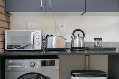 a kitchen counter with a microwave and a tea kettle at Modern 2 bed apartment, Secure estate in Midrand