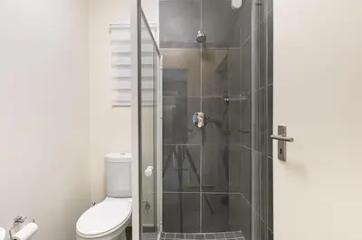 a bathroom with a glass shower with a toilet at Modern 2 bed apartment, Secure estate in Midrand